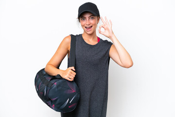 Young sport woman with sport bag isolated on white background showing ok sign with fingers