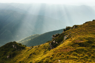 Amazing landscape in the mountains at morning. View of sun rays over hills and valleys. Beam of light from clouds on the mountains. The Maramures Natural Park. Carpathians. Romania. Europe.