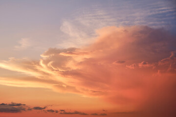 Fototapeta na wymiar Big clouds in the red sunset sky. Evening sky in bright sunlight