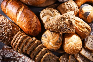 Fototapeten Verschiedene Backwaren, darunter Brotlaibe und Brötchen © monticellllo
