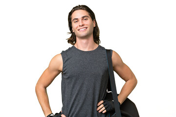 Young sport handsome man isolated on green chroma background posing with arms at hip and smiling