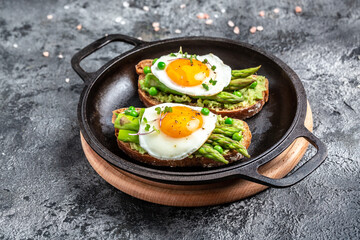 Tasty breakfast. avocado, asparagus, jamon, ham, prosciutto and fried egg on white plate. Ketogenic diet. Low carb high fat breakfast, top view