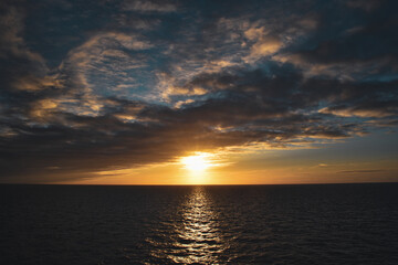 Naklejka na ściany i meble orange yellow blue sunrise sunset reflection over ocean sea 