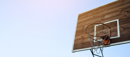 Banner basketball hoop, metal net and wooden backboard for game on blue sky background. Basketball...
