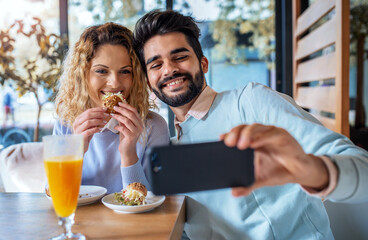 Young couple sitting in a cafe, having breakfast. Love, dating, food, lifestyle concept