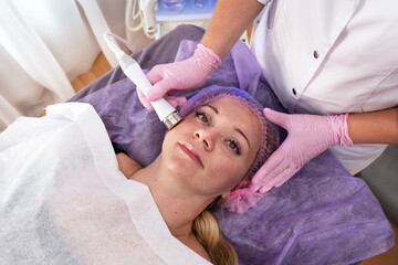 Obraz na płótnie Canvas Cosmetology skincare procedure. Beauty treatment with cooling blue light.