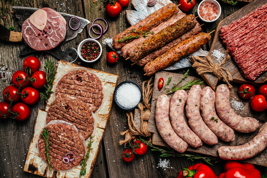 Raw meat products, different parts of the body. minced beef meat kebabs, pork, beef, chicken on a wooden background. banner, menu, recipe place for text, top view