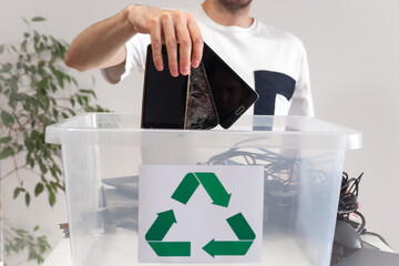 Man throwing away broken mobile phones in recycle container. Hazardous E-Waste Recycling. Waste...