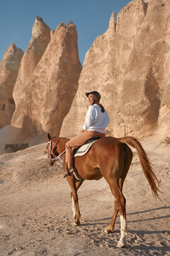 Woman tourist riding a horse in the valley at Goreme Cappadocia Turkey. High quality photo
