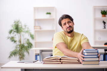Obraz premium Young male student preparing for exams in the classroom