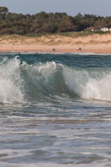 detail of sea waves with foam during a surf and travel week experience in Somo, Cantabria (Spain)