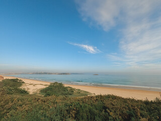 panoramic view of a beach with calm sea by day during a surf and travel week experience in Somo, Cantabria (Spain)