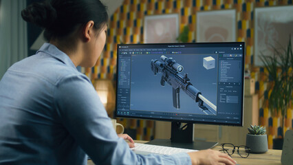 Female 3D designer creating 3D model of gun and making graphic using software for modeling 3D projects on pc while working at home