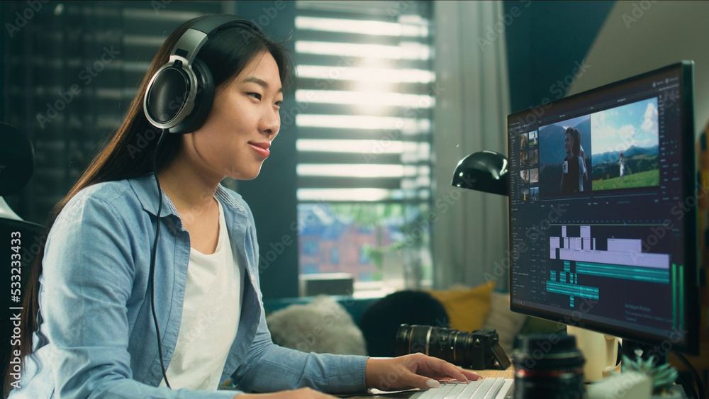Aufkleber female asian freelancer editing video for customer or travel blogger in program on computer while si