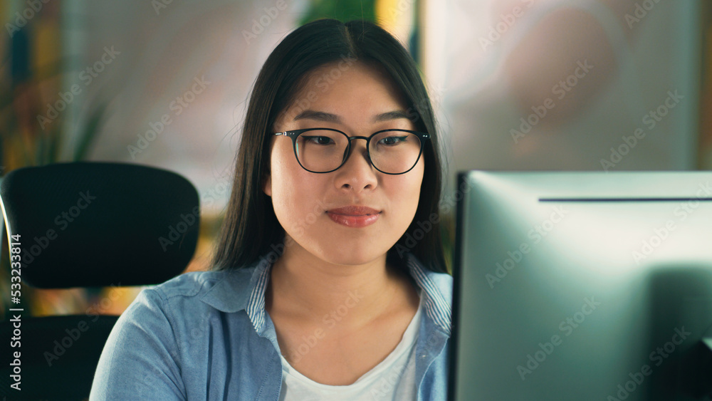 Aufkleber asian woman in glasses looking at screen of computer while working on 3d modeling project or design 