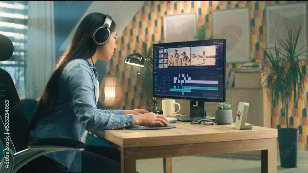Poster asian woman in headphones editing video for blog about space in professional software on computer wh