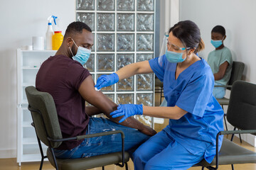 Fototapeta premium Black man with face mask being vaccinated