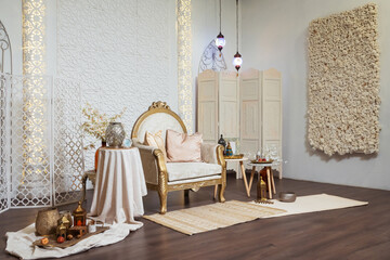 light armchair with tables in oriental style. oriental photo zone in a photo studio with lamps and...