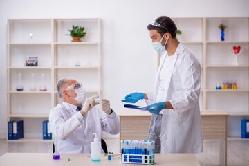 Two male chemist working at the lab