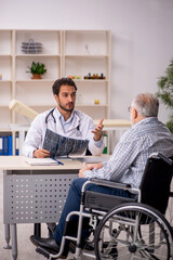 Old injured man visiting young male doctor radiologist