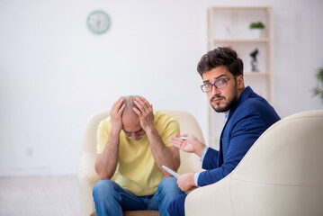 Old man visiting young male psychotherapist