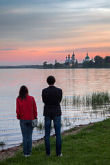 Fototapeta premium A young couple admire the sunset over the Spaso-Yakovlevsky Monastery in Rostov the Great (Russia)