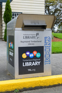 Raymond, WA, USA - September 14, 2022; Metal book drop box alongside yellow kerb at Raymond Timberland Library
