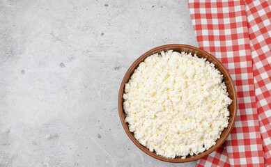 Cottage curd cheese in a wooden bowl grey table background