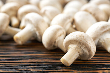champignon mushrooms on a  brown wooden table selective focus.