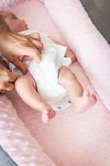 Selective focus of man's hands putting diaper on a baby