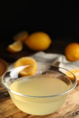 Freshly squeezed lemon juice in glass bowl on wooden table