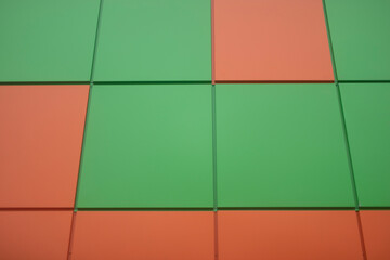 Orange and green tiles. Wall of squares.