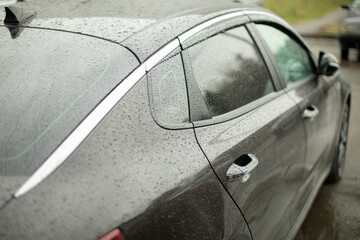 Black premium car. Transport in raindrops.