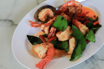 Stir Fried Shrimp or prawns with Chili and kaffir lime leaves on white plate. ฏelicious Thai food.