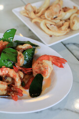 Stir Fried Shrimp or prawns with Chili and kaffir lime leaves on white plate. ฏelicious Thai food.