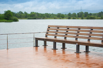 Obraz premium Wooden seats near the waterfront, a corner to relax in the park to see the natural scenery.