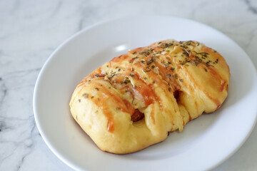 Sausage buns bread. Soft baked bun (dough) stuffed with sausage for fast food breakfast or coffee break. Sausage roll, (hot dog). With mayo, tomato sauce, mozarella cheese and parsley topping