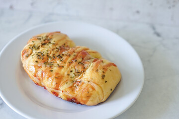 Sausage buns bread. Soft baked bun (dough) stuffed with sausage for fast food breakfast or coffee break. Sausage roll, (hot dog). With mayo, tomato sauce, mozarella cheese and parsley topping