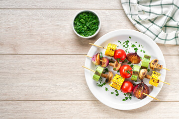 vegetable kebabs on skewers grilled on grill or BBQ on a white table, copy space for text.