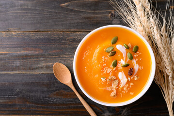 Butternut squash pumpkin soup in bowl on wooden background, Homemade food in autumn season