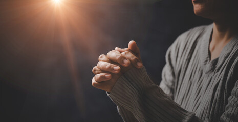 Christ religion and christianity worship or pray concept. Christian catholic woman are praying to god in dark at church. Prayer person hand in black background. Girl believe and faith in jesus christ. - obrazy, fototapety, plakaty