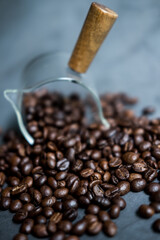 Obraz premium Scattered coffee beans from a transparent glass. Close up