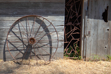Fototapeta na wymiar Rusted iron wheel in front of abandoned tool shed on Santa Cruz Island in the Channel Islands National Park near Santa Barbara California in the United States