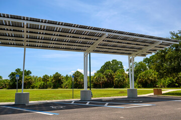 Fototapeta na wymiar Solar panels installed as shade roof over parking lot for parked electric cars for effective generation of clean electricity. Photovoltaic technology integrated in urban infrastructure