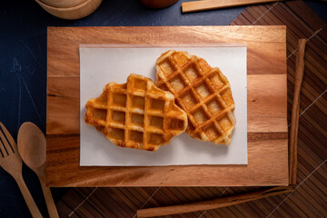 Delicious Waffle and Croissants in wooden plate on wooden table, Freshly baked croissants and Waffle on brown wooden table.