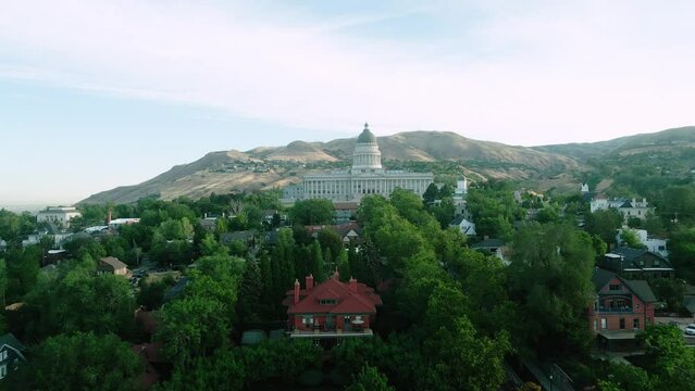 cinematic slow push in of Utah State Capitol Building in Salt Lake City above trees and houses at 5am in the morning