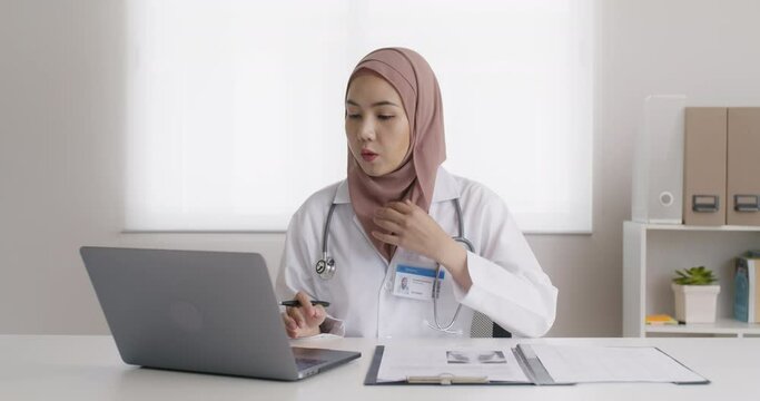 Islam arab GP video call talk share on telemedicine telehealth teleconsult clinic platform app at office desk. Young medic health care worker work for asia people tele consult on online remote visit.