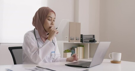 Islam arab GP video call talk share on telemedicine telehealth teleconsult clinic platform app at office desk. Young medic health care worker work for asia people tele consult on online remote visit.