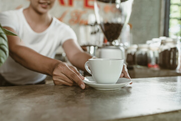 Barista serving a coffee to customer at the coffee shop.