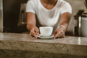 Barista serving a coffee to customer at the coffee shop.